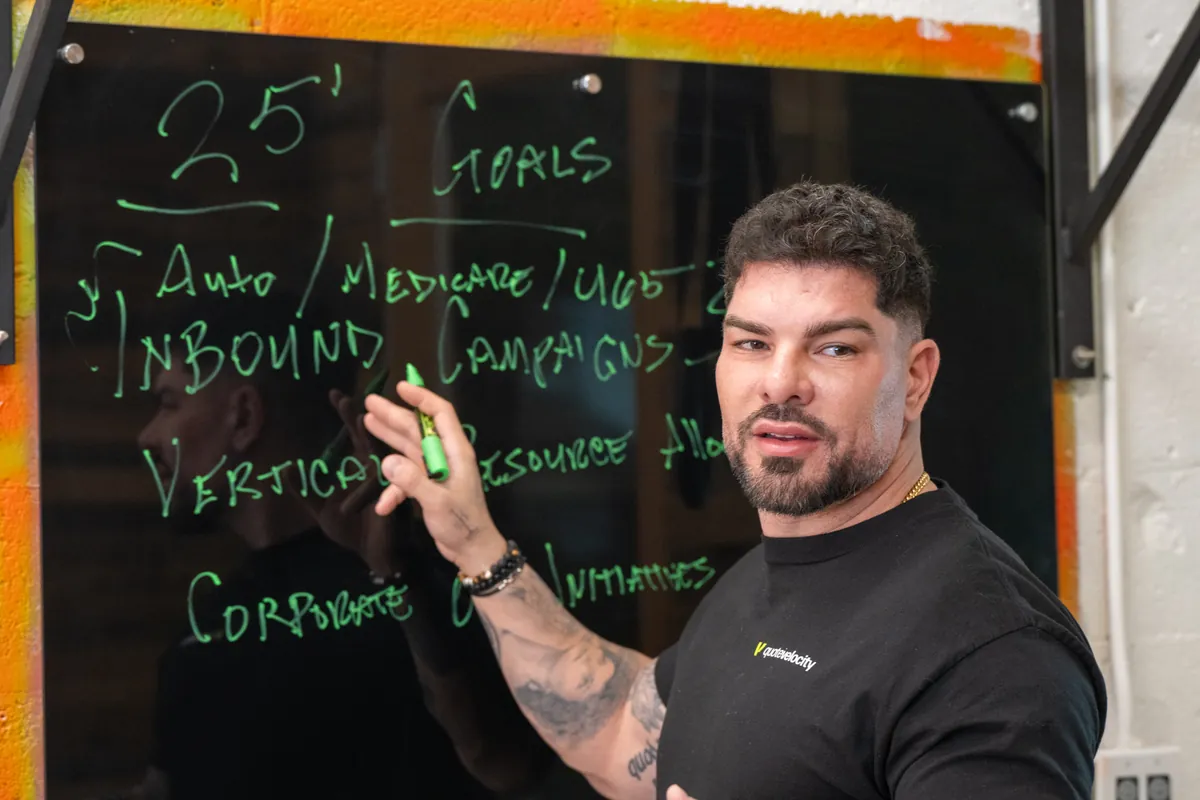 Manny Zuccarelli planning Quote Velocity campaigns at the office whiteboard
