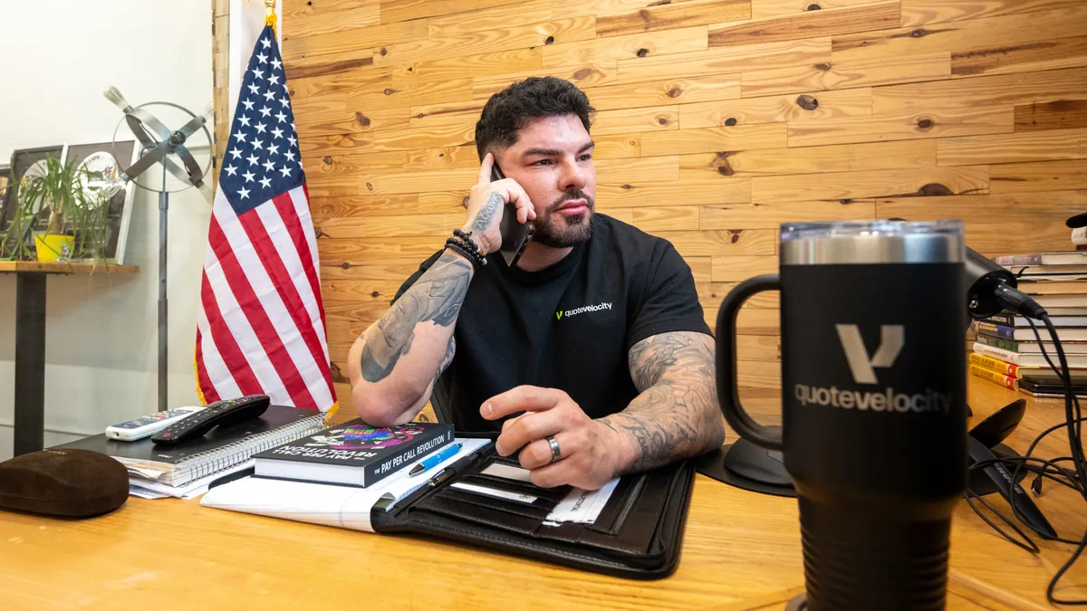 Manny Zuccarelli taking a call at his Quote Velocity desk